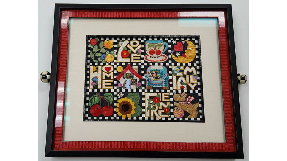 Framed needlepoint folk art